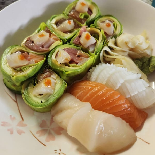 Elite Five Sushi & Grill's plate of sushi rolls wrapped in avocado, salmon, and scallop nigiri.